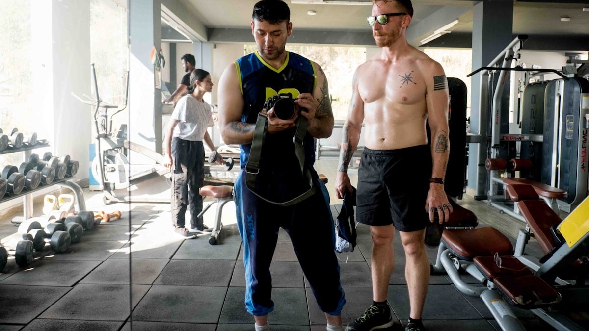 a couple of men standing next to each other in a gym